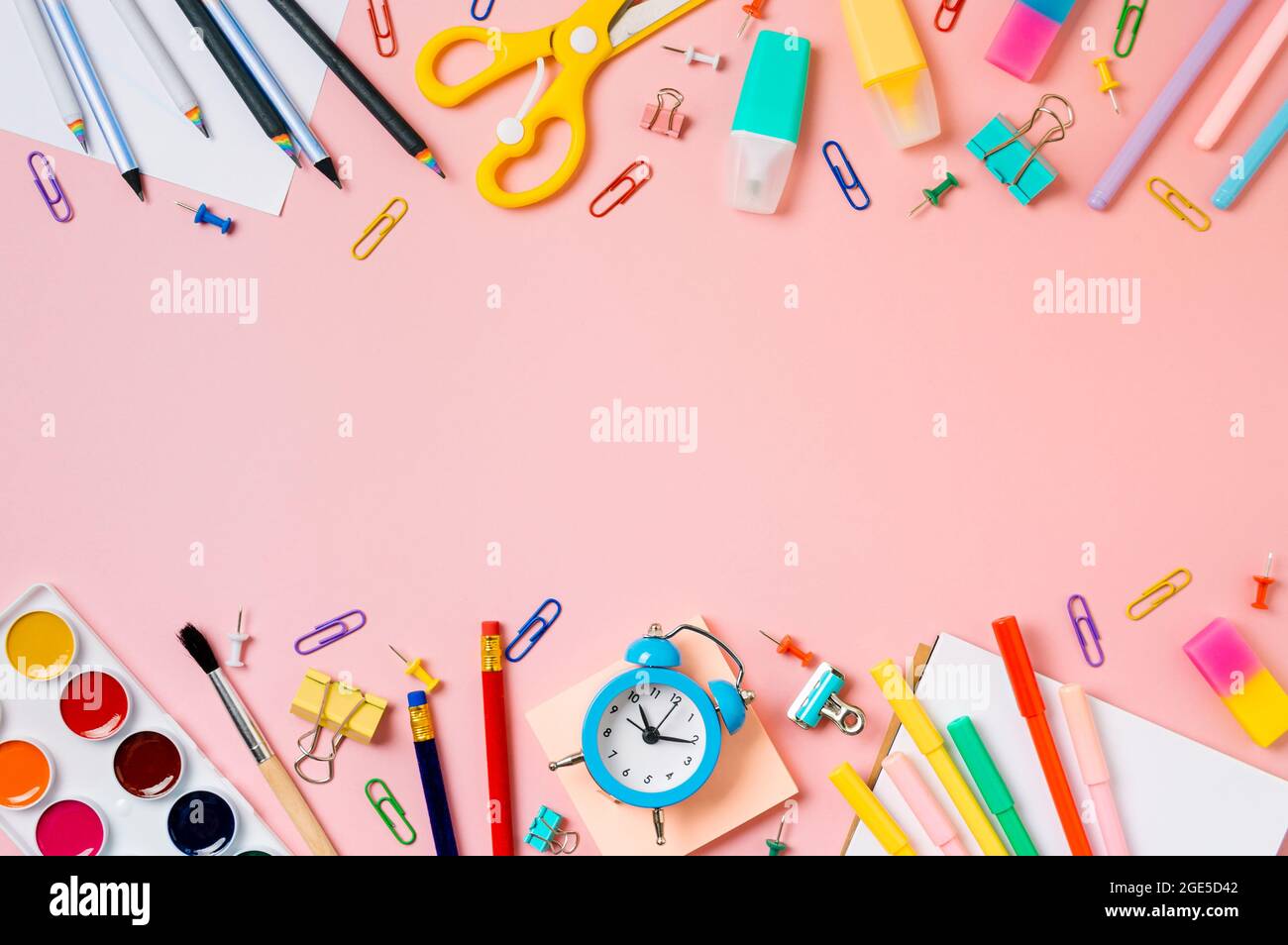Creative student desk with school supplies and copy space in center. Top view or flat lay. Trendy back to school flat lay on pink background Stock Photo