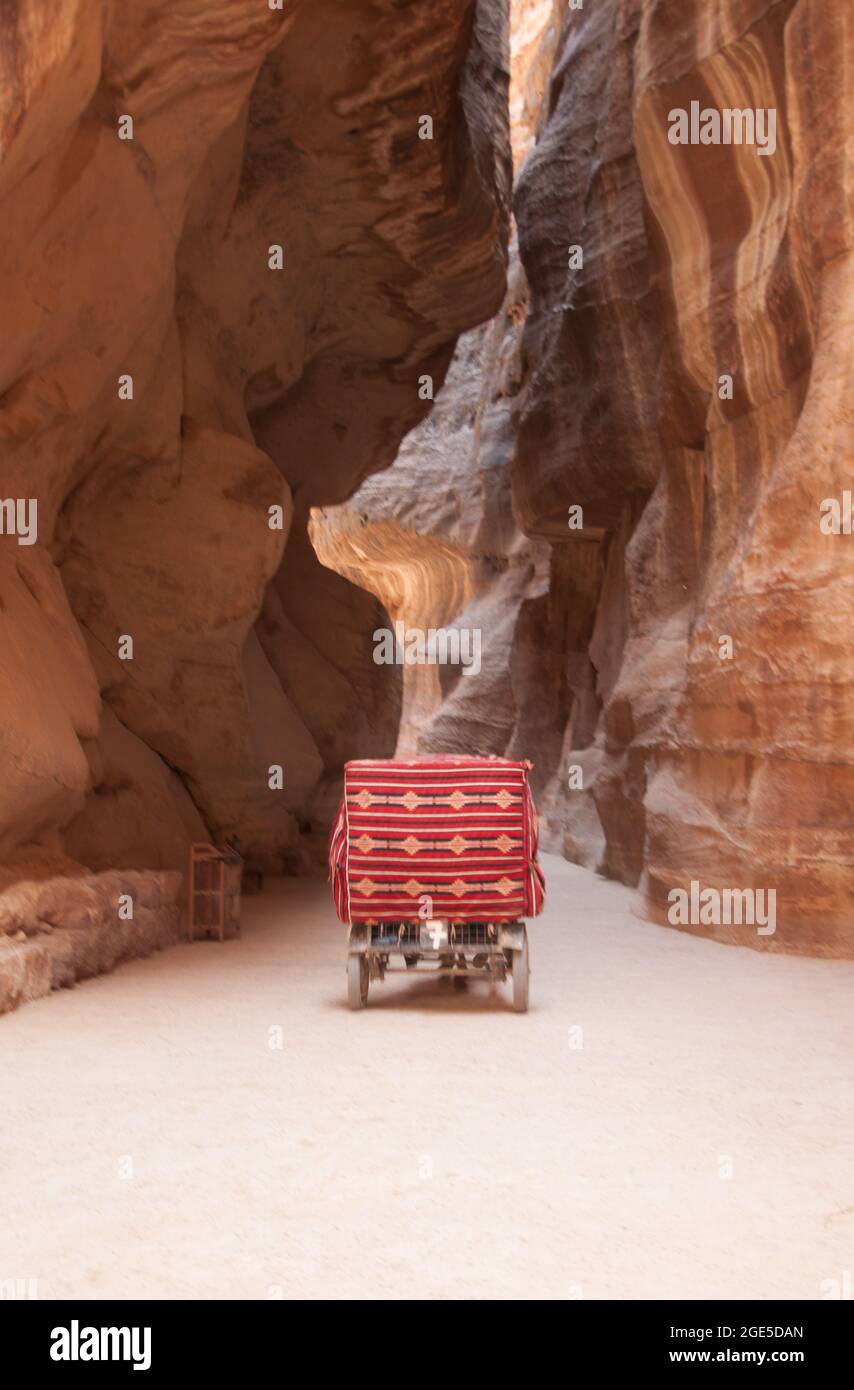 Carriage in The Siq, Petra, Jordan, Middle East.  The Siq is a natural split in the rock forming a passageway through to the 'Hidden City of Petra'. Stock Photo