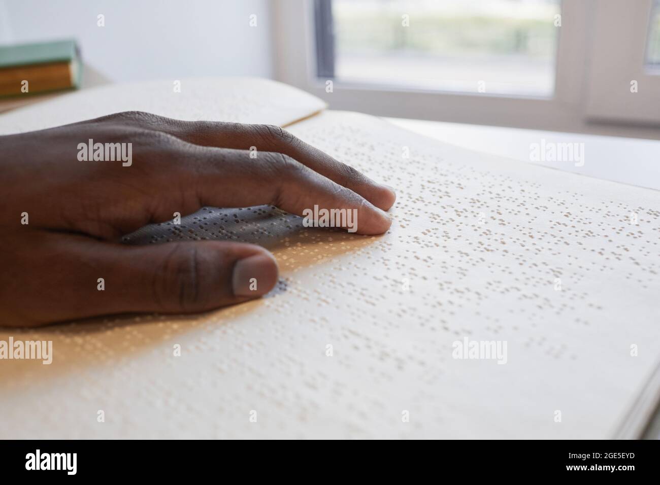 Close up of African-American hand reading braille book for blind, copy space Stock Photo