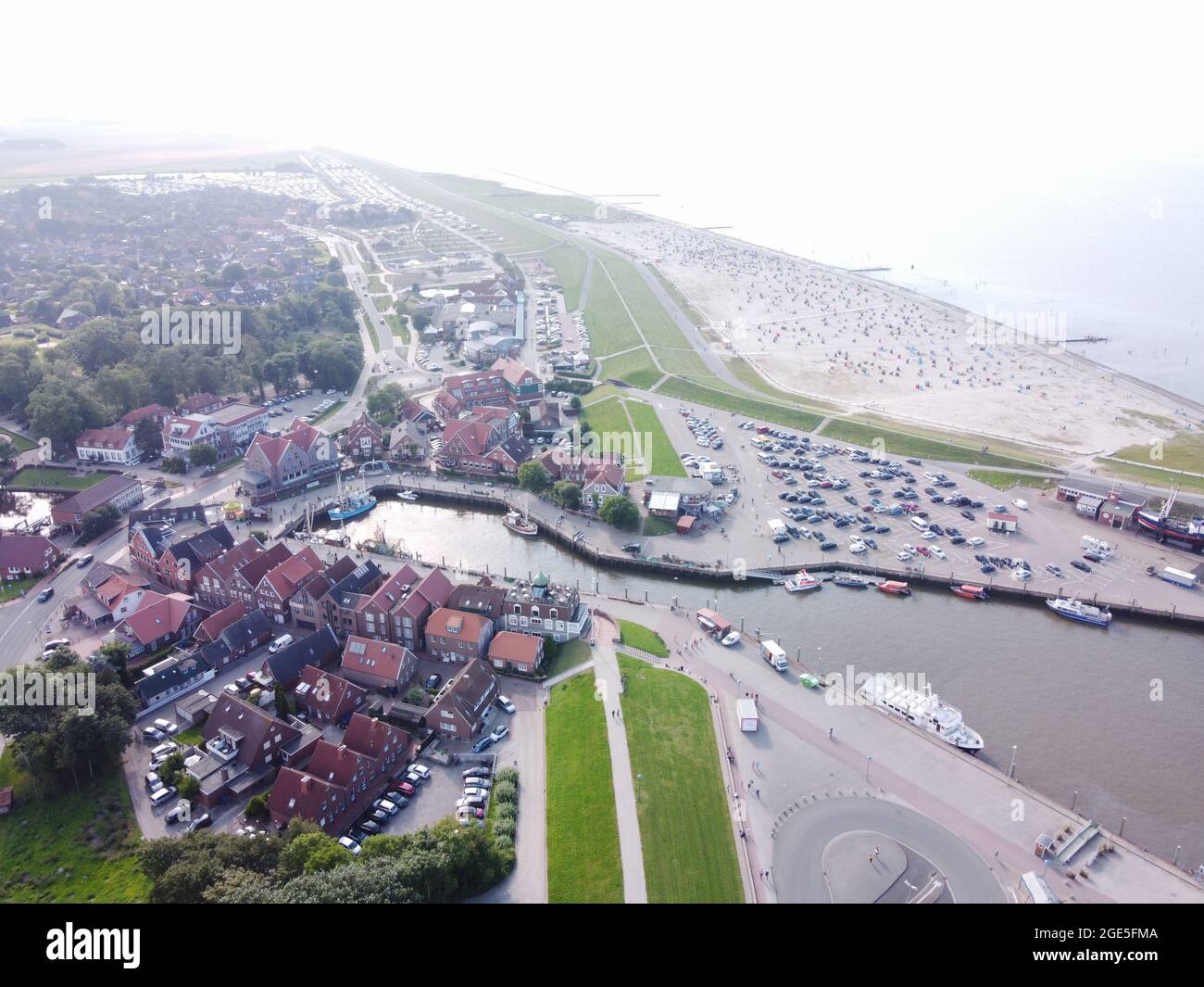 Aerial view of North Sea resort Neuharlingersiel in East Frisia, Lower Saxony, Germany. Drone view of fishing village on the Wadden Sea coast. Stock Photo
