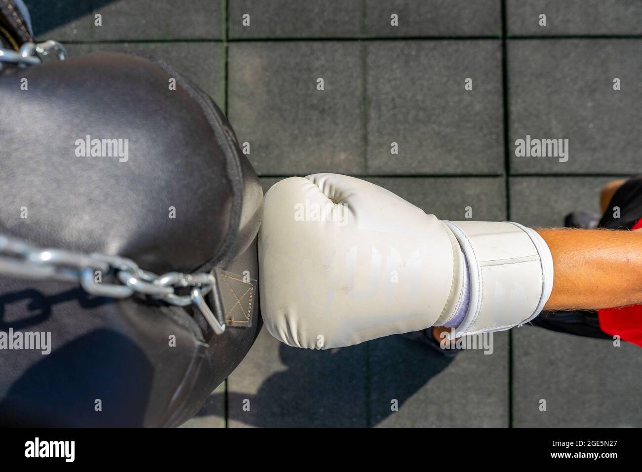 View from above of a fist with a white boxing glove hitting a punching