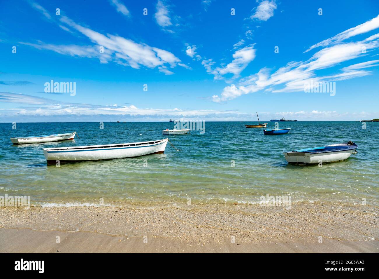 Fishing boats in turquoise green water on the beach at Bain des Dames, fishing spot found near Cassis in Port Louis, Mauritius, Africa Stock Photo