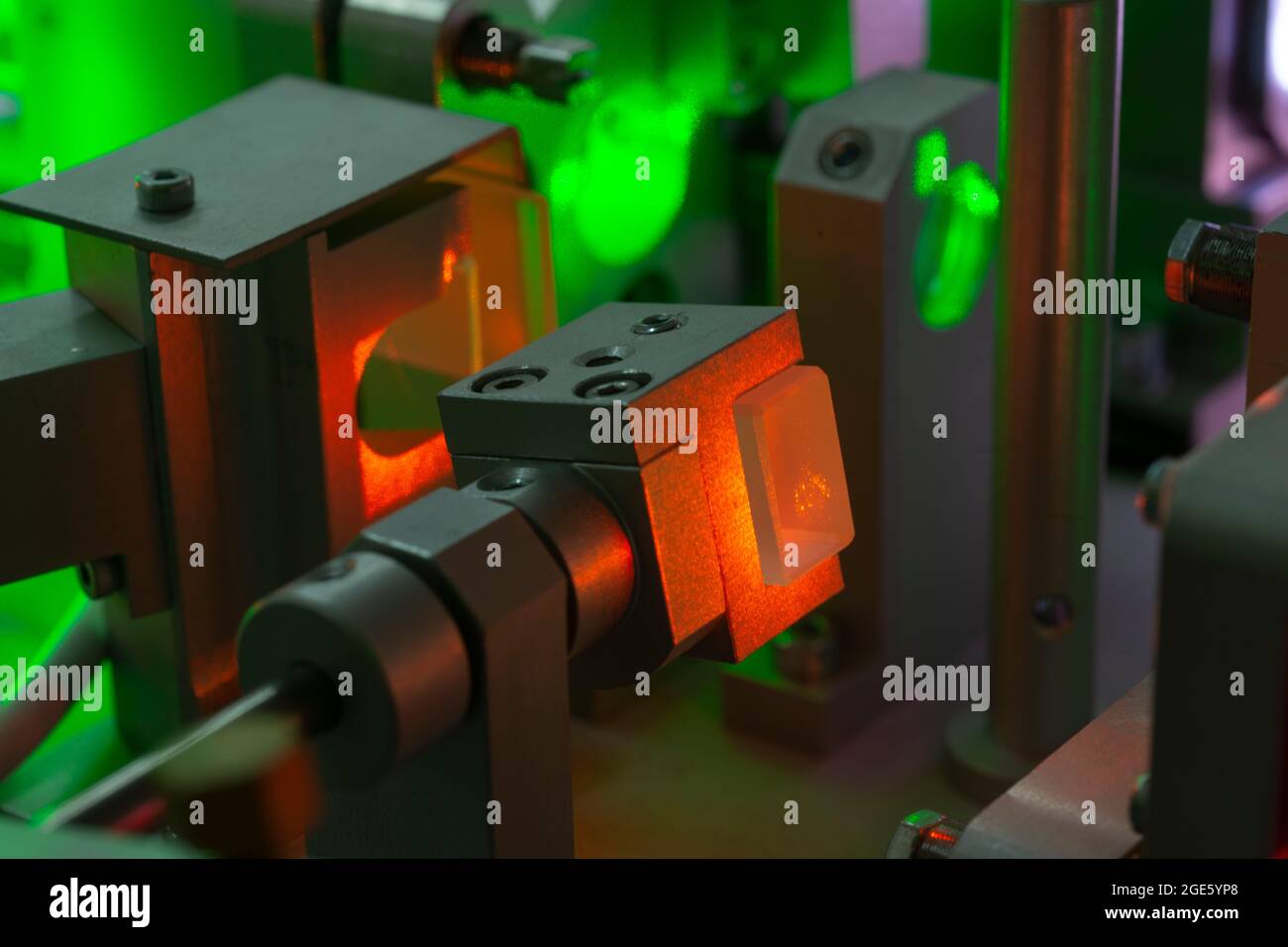 focus on laser crystal of optical parametric oscillator during operation, bright spots have typical speckle structure - it is feature of laser light Stock Photo