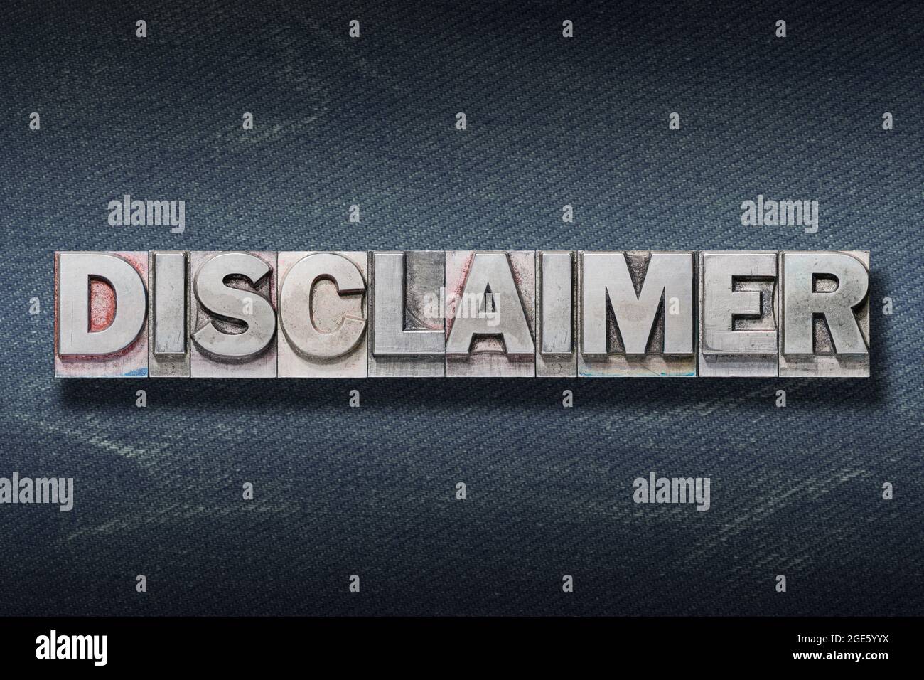 disclaimer word made from metallic letterpress on dark jeans background Stock Photo