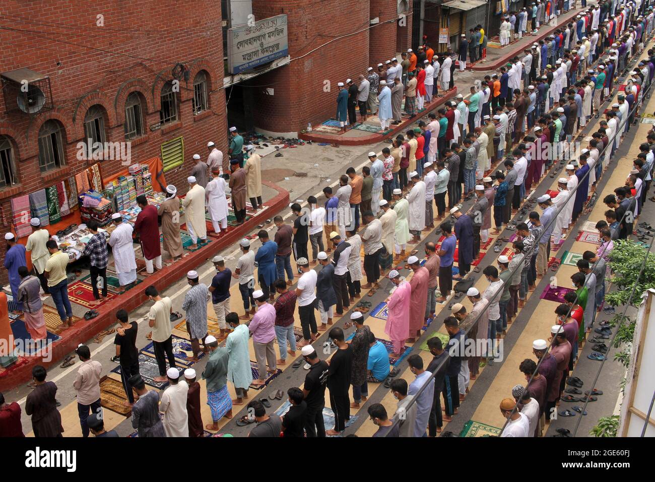 DHAKA, BANGLADESH  -AUGUST 13: Aerial view of thousands of Muslims meeting  take part during a mass  Jummah Prayer, Due this Islamic ritual is mandatory act, it is performed every Friday to fulfill its obligations as a faithful.  Jummah is the holiest day of the week on which special congregational prayers are offered. Fridays are considered a celebration in their own right and Muslims take special care in wearing clean clothes, bathing, and preparing special meals on this day. On August 13, 2021 in Dhaka, Bangladesh. Credit: Eyepix Group/The Photo Access Stock Photo