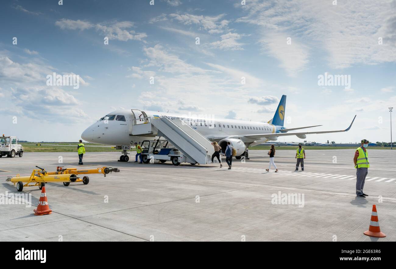 Ukraine, Odessa - August 3, 2021: At the ODS airport await departure. The plane Embraer E195AR Ukraine International Airlines UIA. Passengers climb Stock Photo