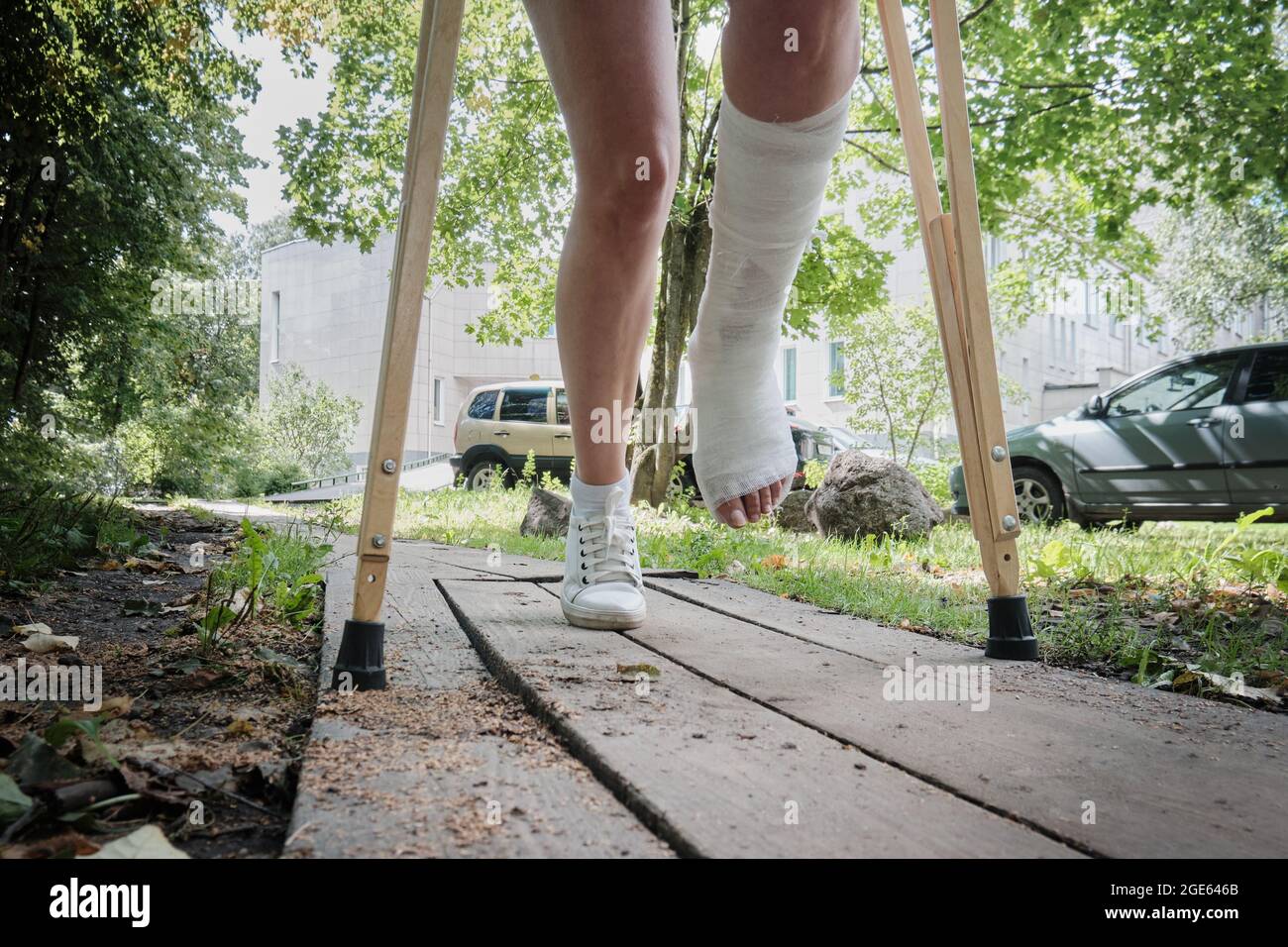 A woman with a broken leg walks down a ramp using orthopedic crutches Stock Photo Alamy