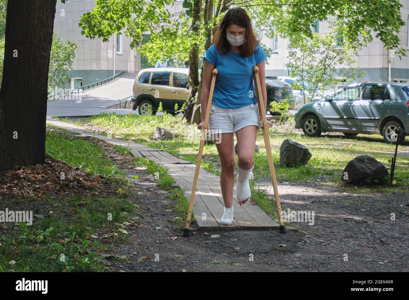 A woman with a broken leg walks down a ramp using orthopedic crutches Stock Photo Alamy