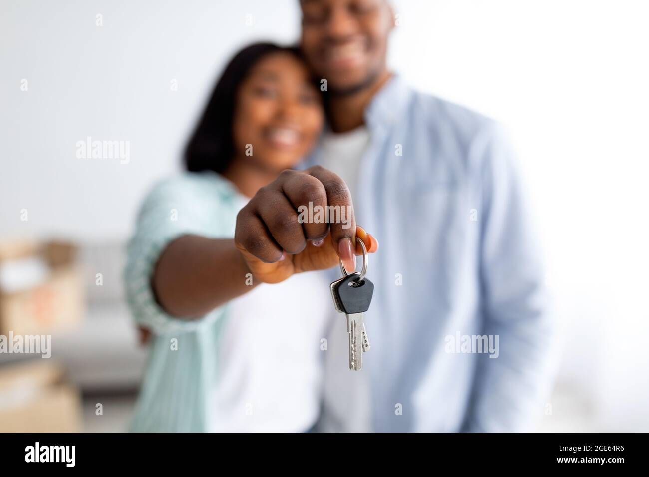 Family housing concept. Happy african american spouses holding new house key, selective focus, shallow depth. Real estate, property ownership and mort Stock Photo
