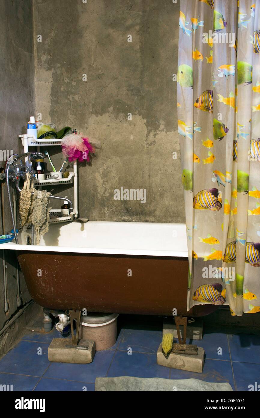 Repair in the house. Bathroom. Old cast-iron bath. The room is not renovated. Stock Photo