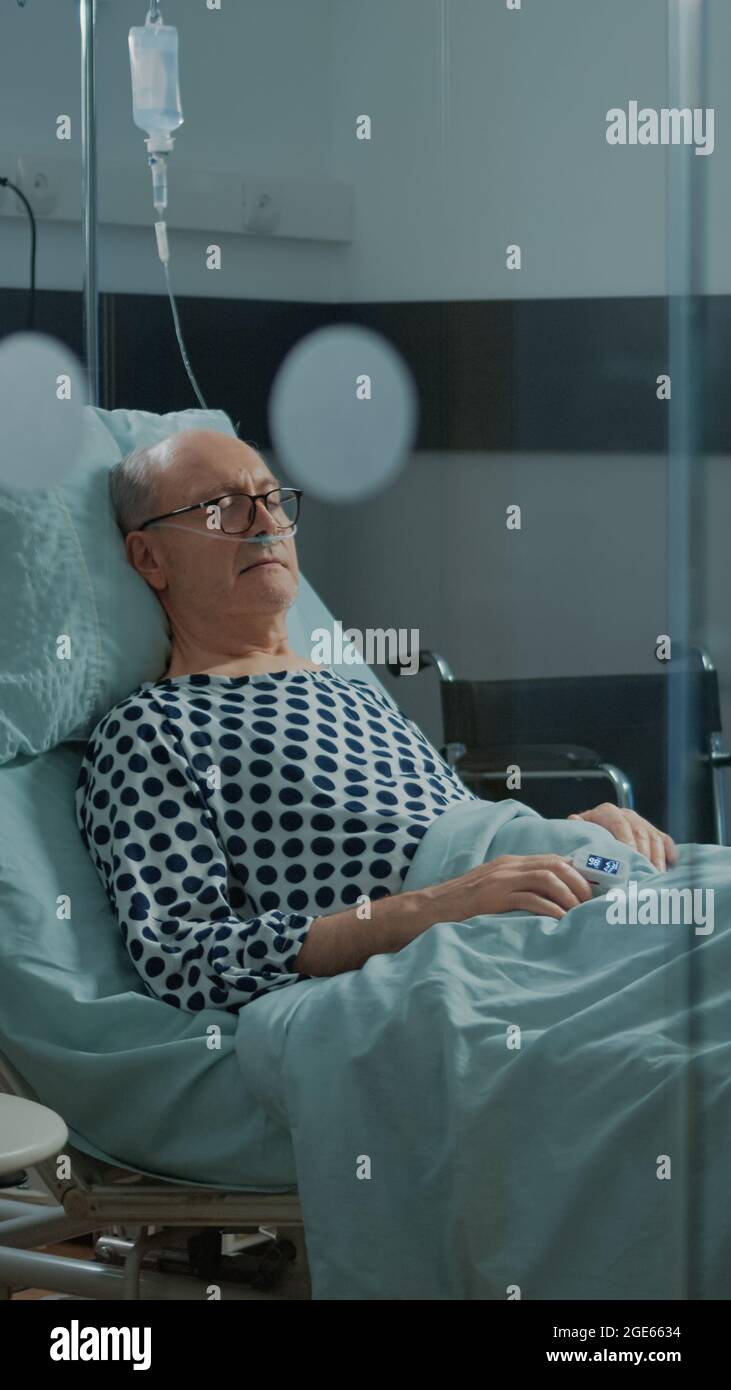 Sick patient sleeping in hospital ward bed at health facility with