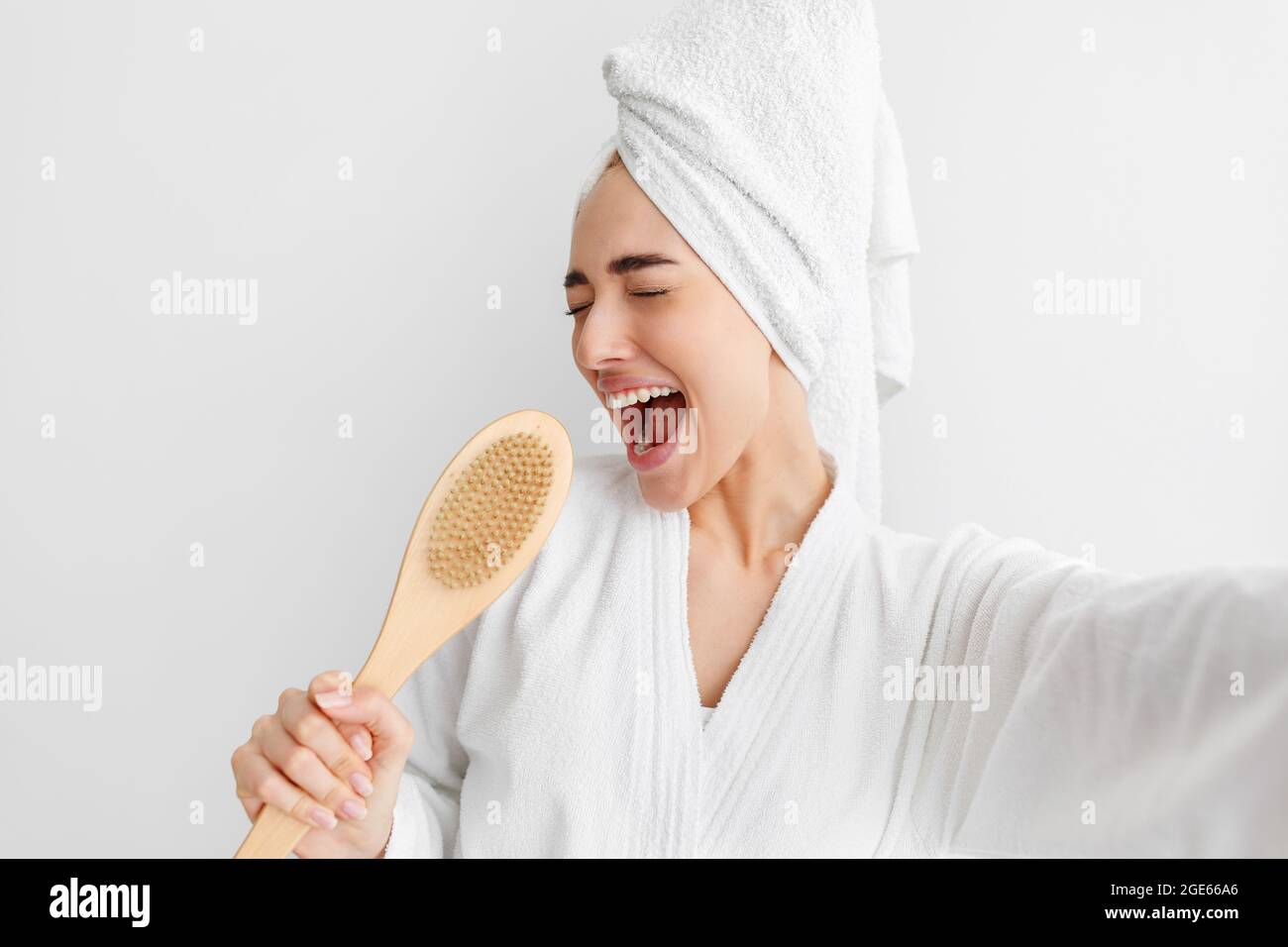 Happy woman, facial emotions, bath at home, good temper, singing song hold body brush as microphone, giving way to talent and joy at free time in morn Stock Photo