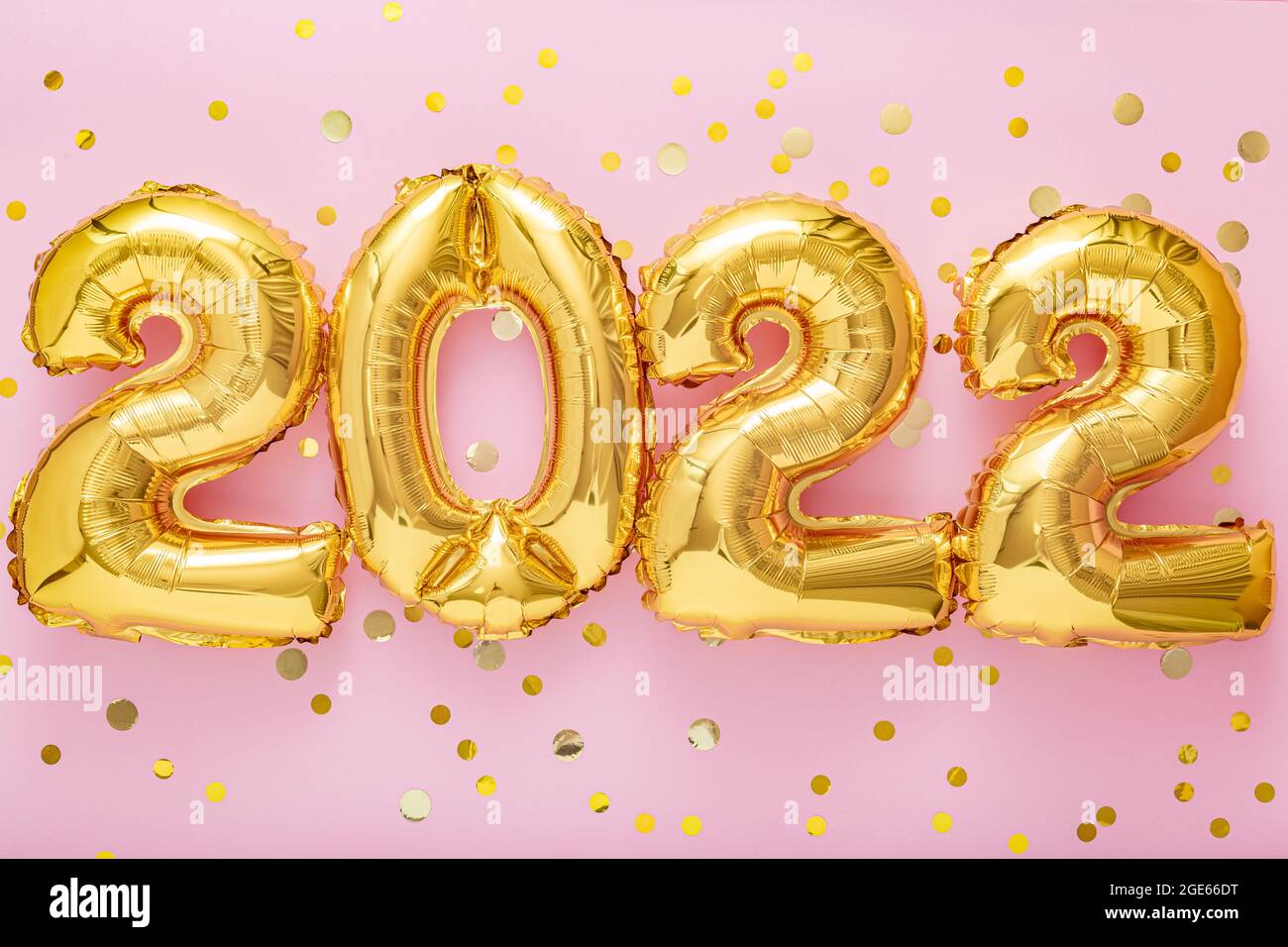 2022 year gold balloons text with confetti on pink color background. Happy New year 2022 lettering eve celebration. Stock Photo