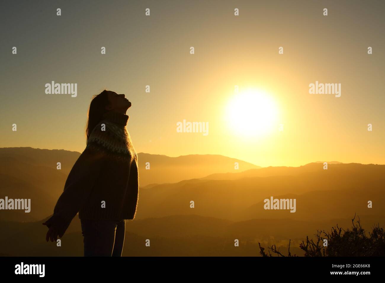 Profile silhouette of a woman breathing fresh air at sunrise in the mountain Stock Photo