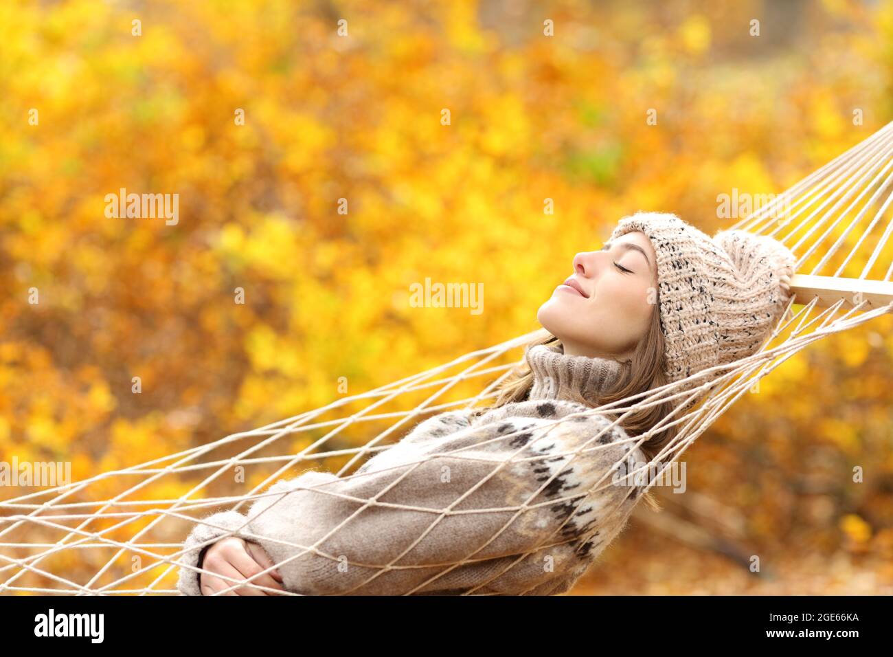 Side view portrait of a woman sleeping on hammock in a forest in autumn Stock Photo