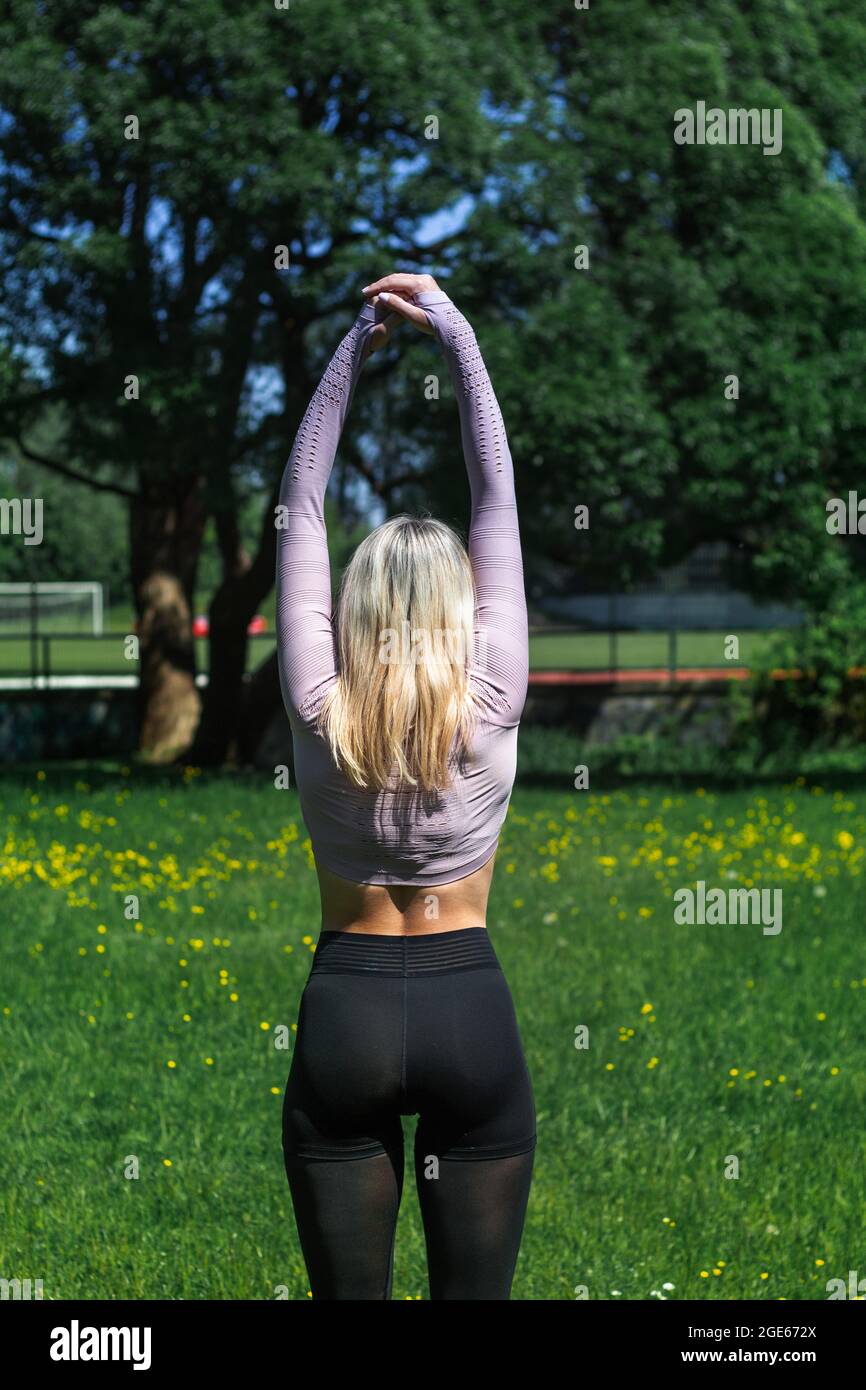 Young caucasian blond-haired woman in sportswear is doing yoga in public  park. Outdoor workout. Yoga poses Stock Photo - Alamy