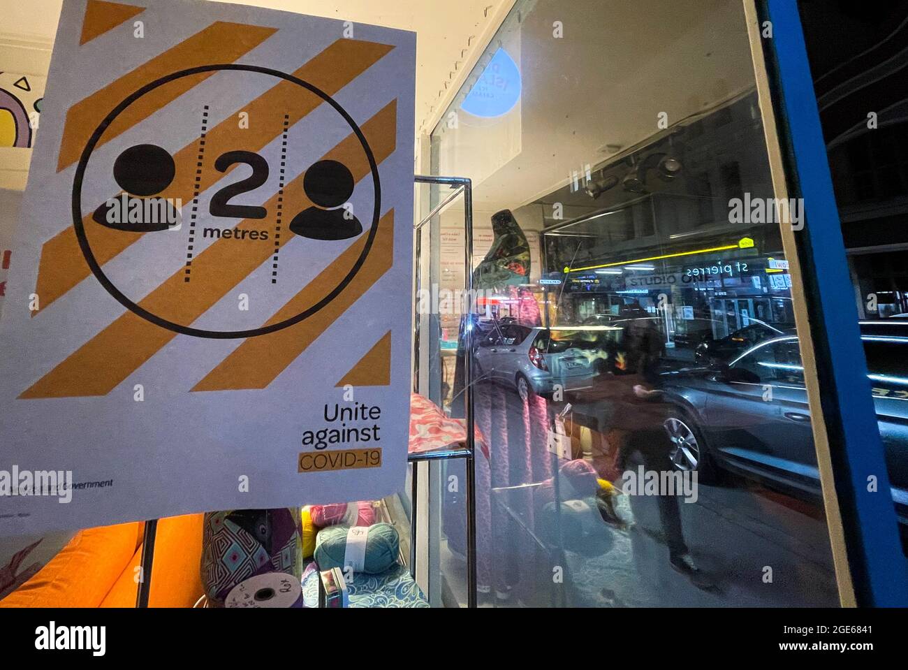 Wellington, New Zealand. 17th Aug, 2021. A pedestrian passes a social  distancing sign on Cuba Street in Wellington, New Zealand, Aug. 17, 2021.  New Zealand will move from current level 1 alert