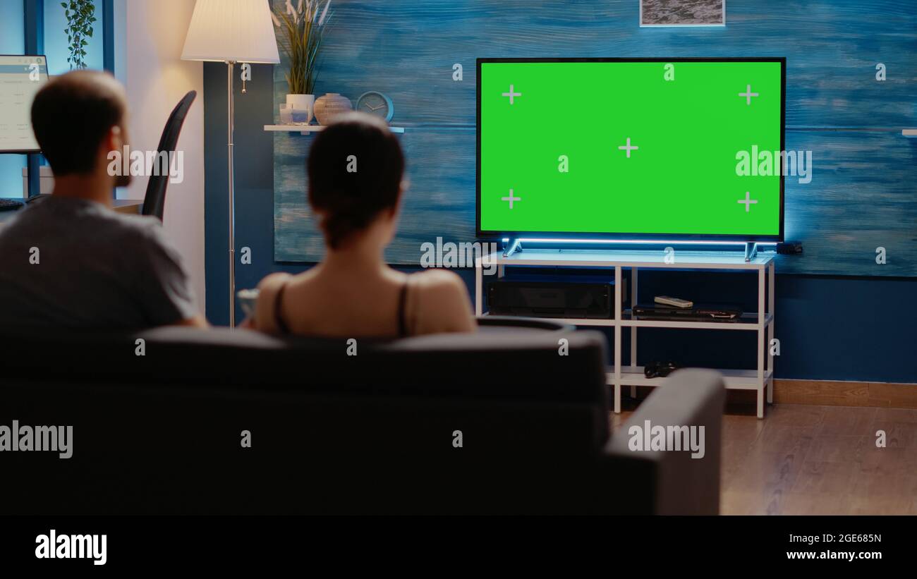 Green screen on television at home in living room used by young man and