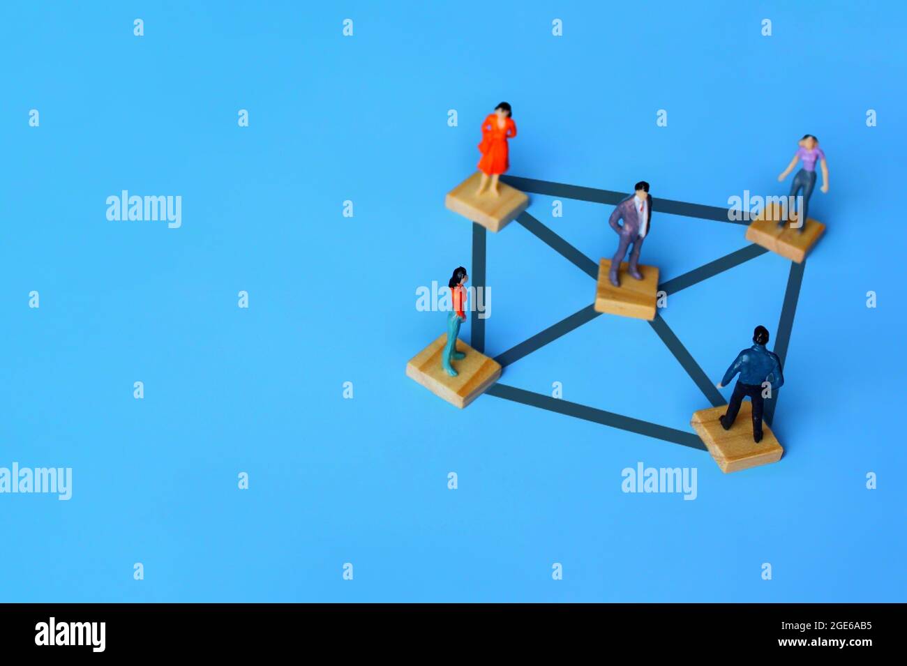 Selective focus image of connected miniature people on wooden cubes. Connection, networking, and social network service concept. Copy space for text Stock Photo