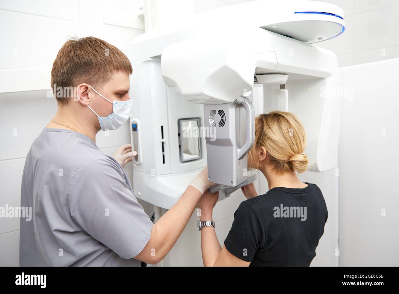 Young woman making panoramic shot of the jaw holding her face at the x-ray machine Stock Photo