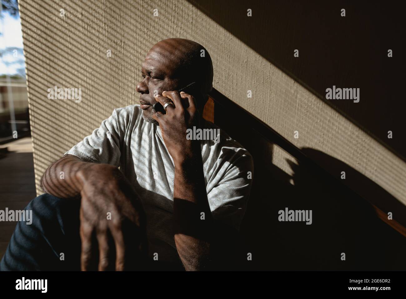 Senior african american man siting on the stairs and talking on the smartphone Stock Photo