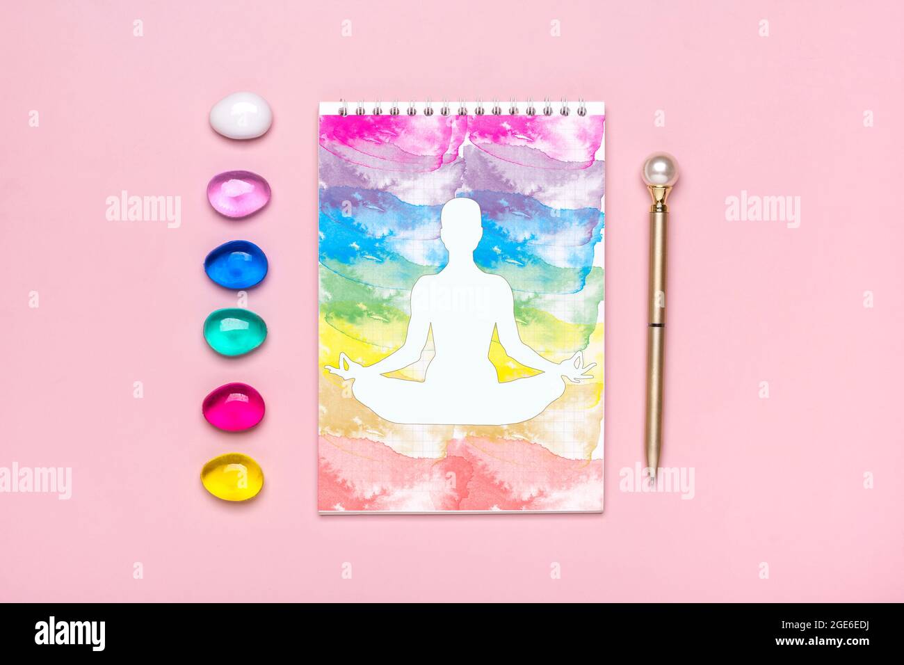 Bright colored rainbow crystal, notepad, pen layout on pink background Reiki alternative medicine concept Top view Expansion of energy Initiation Stock Photo