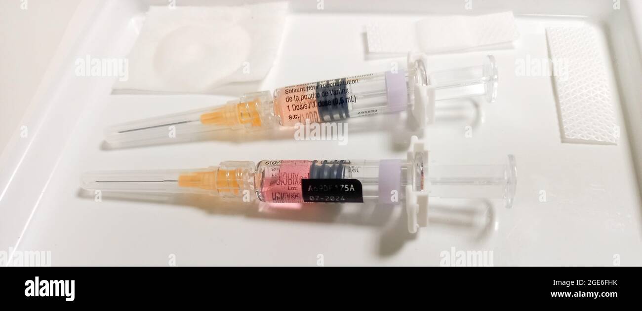 two syringes on a white plate ready for vaccination - injections on a white plate at doctors practice Stock Photo