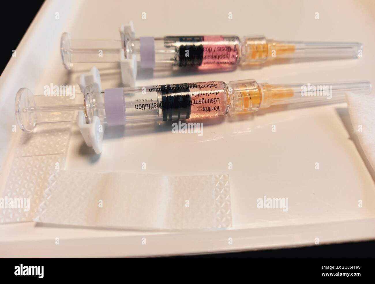 two syringes on a white plate ready for vaccination - injections on a white plate at doctors practice Stock Photo