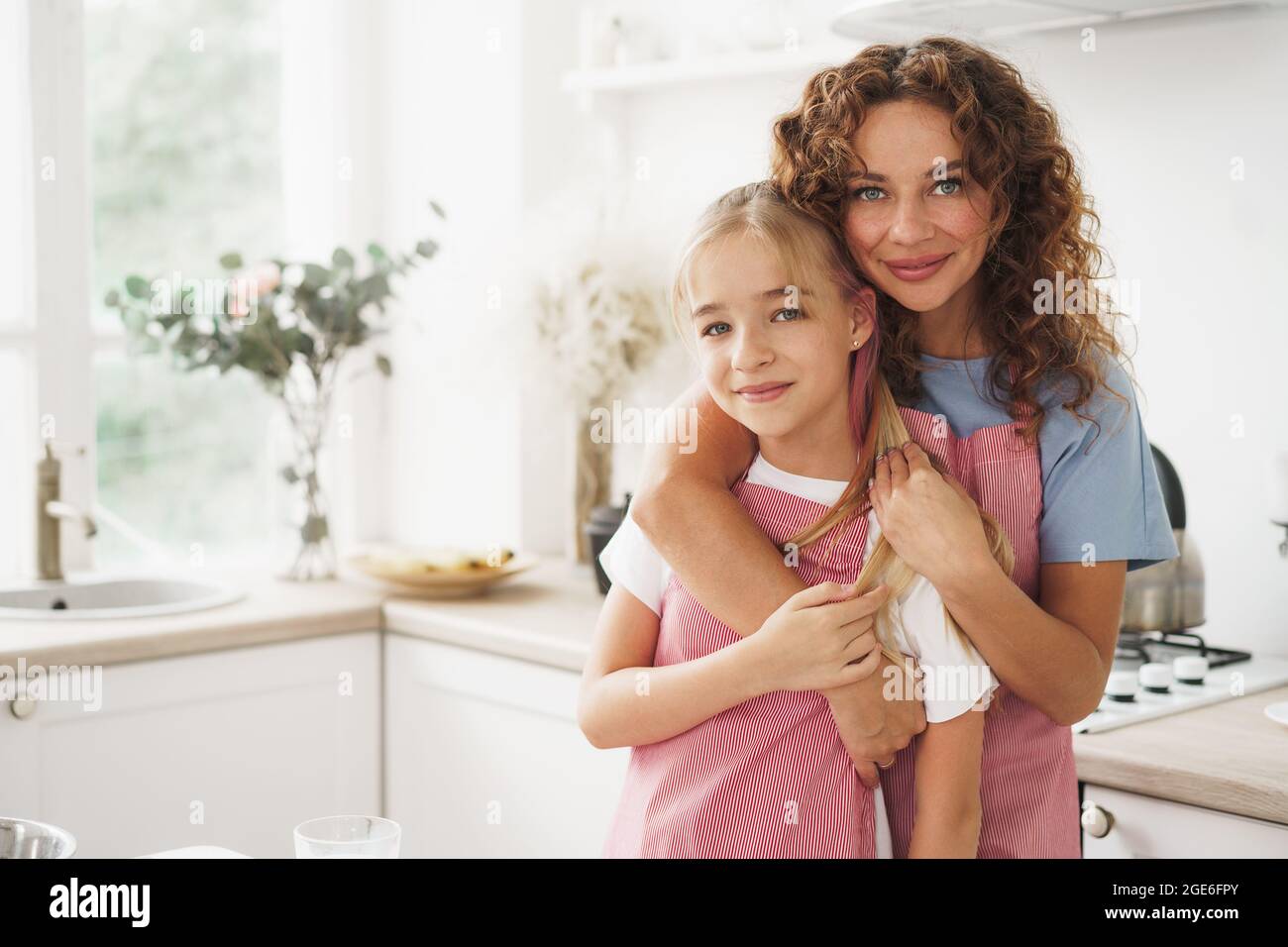 Portrait of a teen girl with her mother at home in kitchen Stock Photo ...