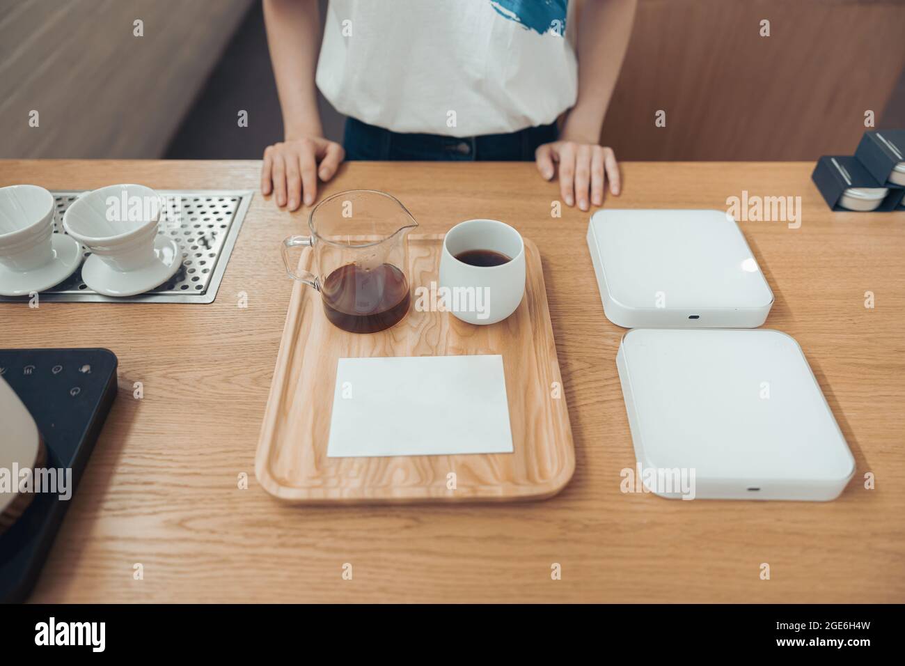 Female barista standing behind counter in coffee shop Stock Photo
