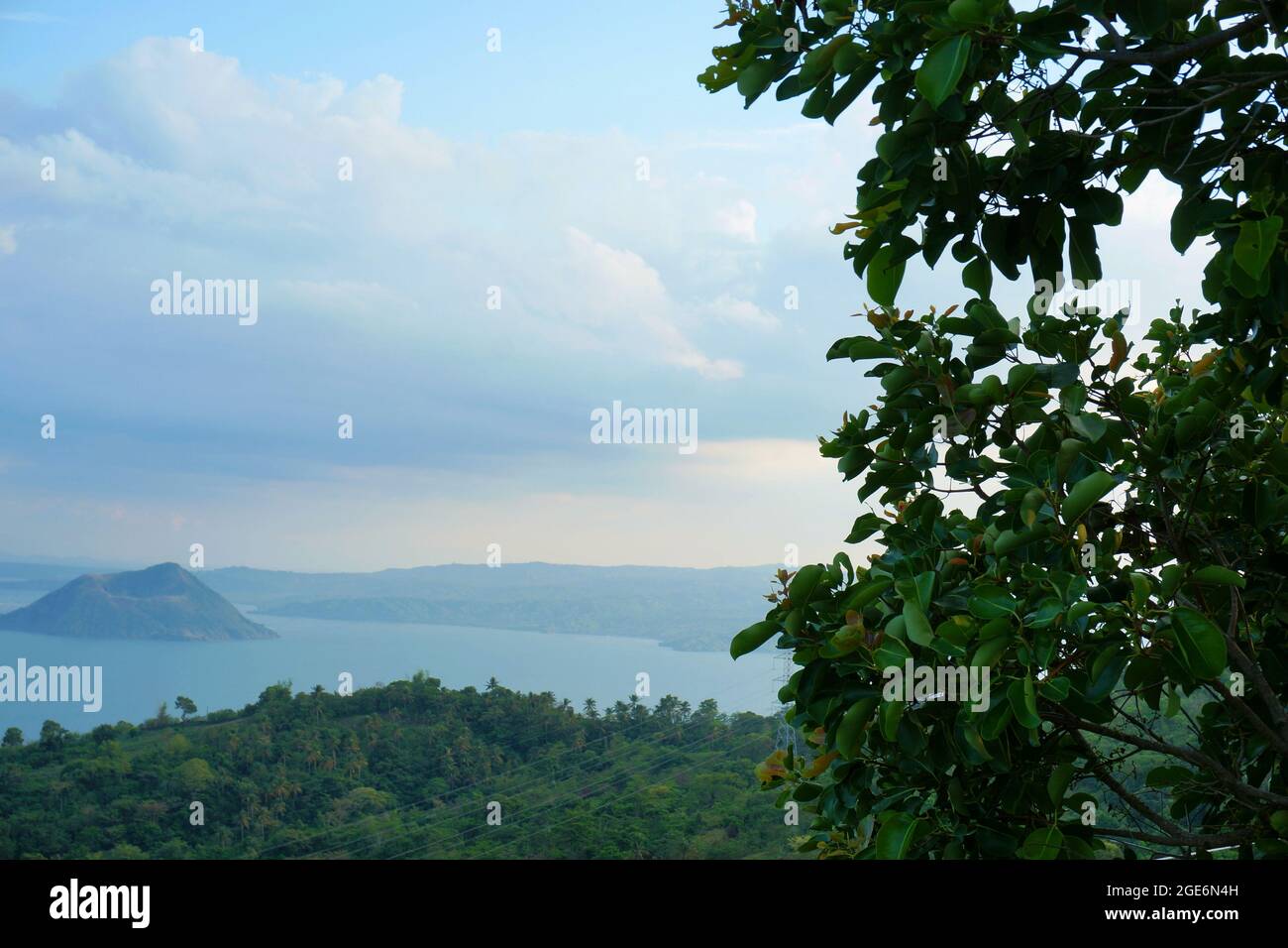Trees and landscapes in foreground and Taal volcano in background in Batangas, Philippines Stock Photo