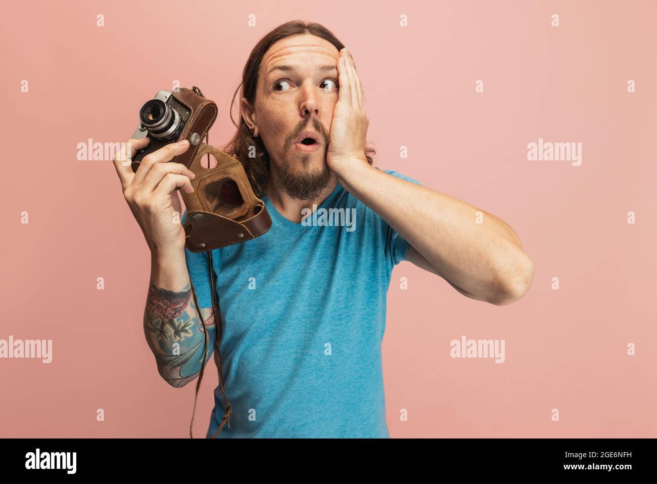 Portrait of young man, photographer, cameraman with retro camera