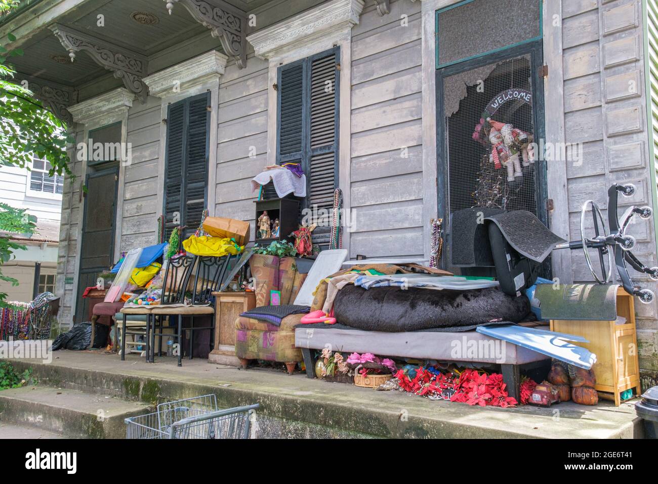 NEW ORLEANS, LA, USA - AUGUST 15, 2021: Dingy shotgun house with cluttered front porch in Uptown Neighborhood Stock Photo