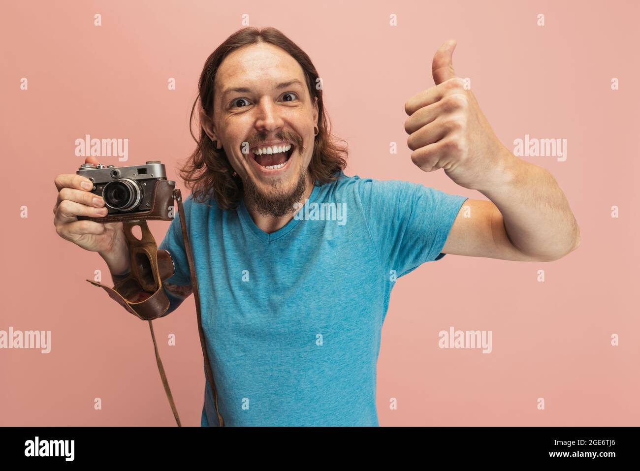 Portrait of young man, photographer, cameraman with retro camera isolated  on pink studio background. Concept of occupation, job, funny meme emotions  Stock Photo - Alamy