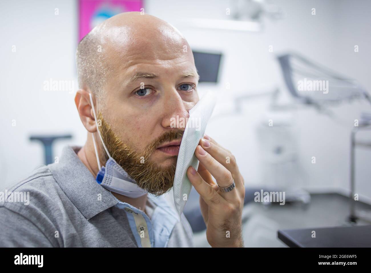 Unhappy And Scared Caucasian Male In A Dental Clinic Waiting For A Check Up And Holding A