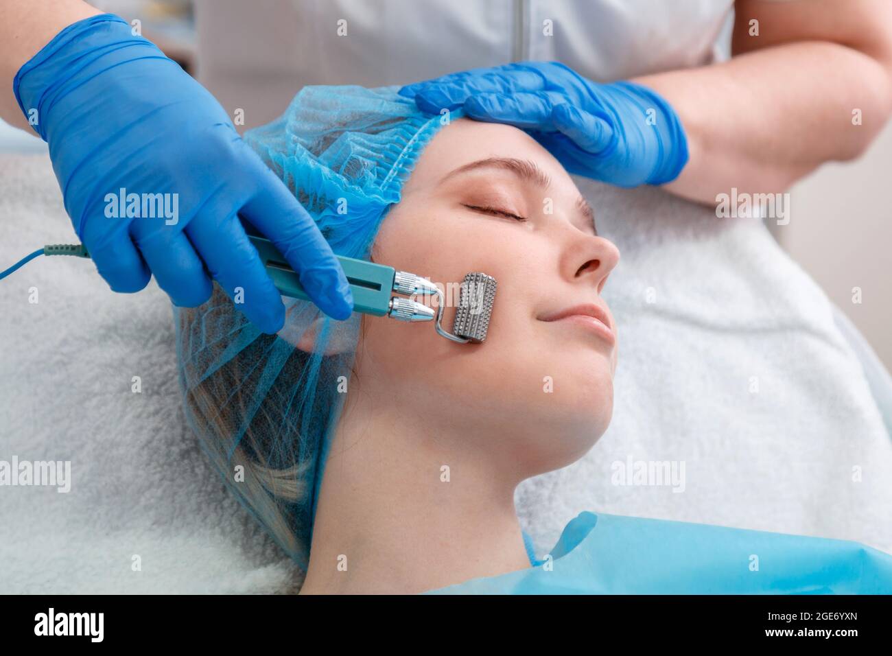 Mesotherapy cosmetology procedures. Doctor cosmetologist doing mesotherapy Cosmetology services to woman with mesoscooter. Hardware cosmetology of Stock Photo