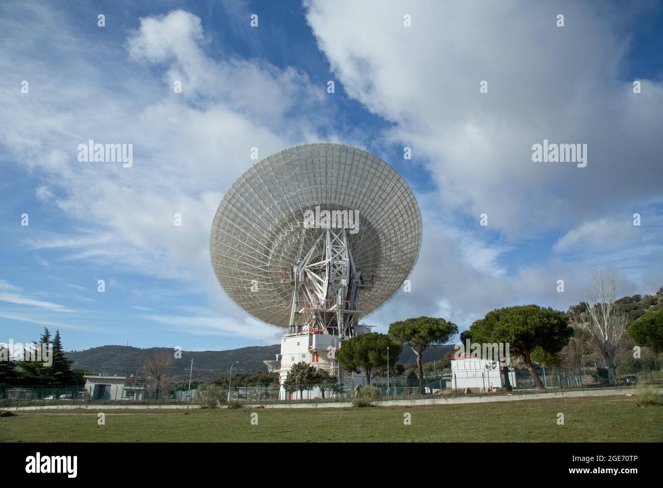 Giant radio telescopes located in valley between mountains with blue sky and clouds Stock Photo