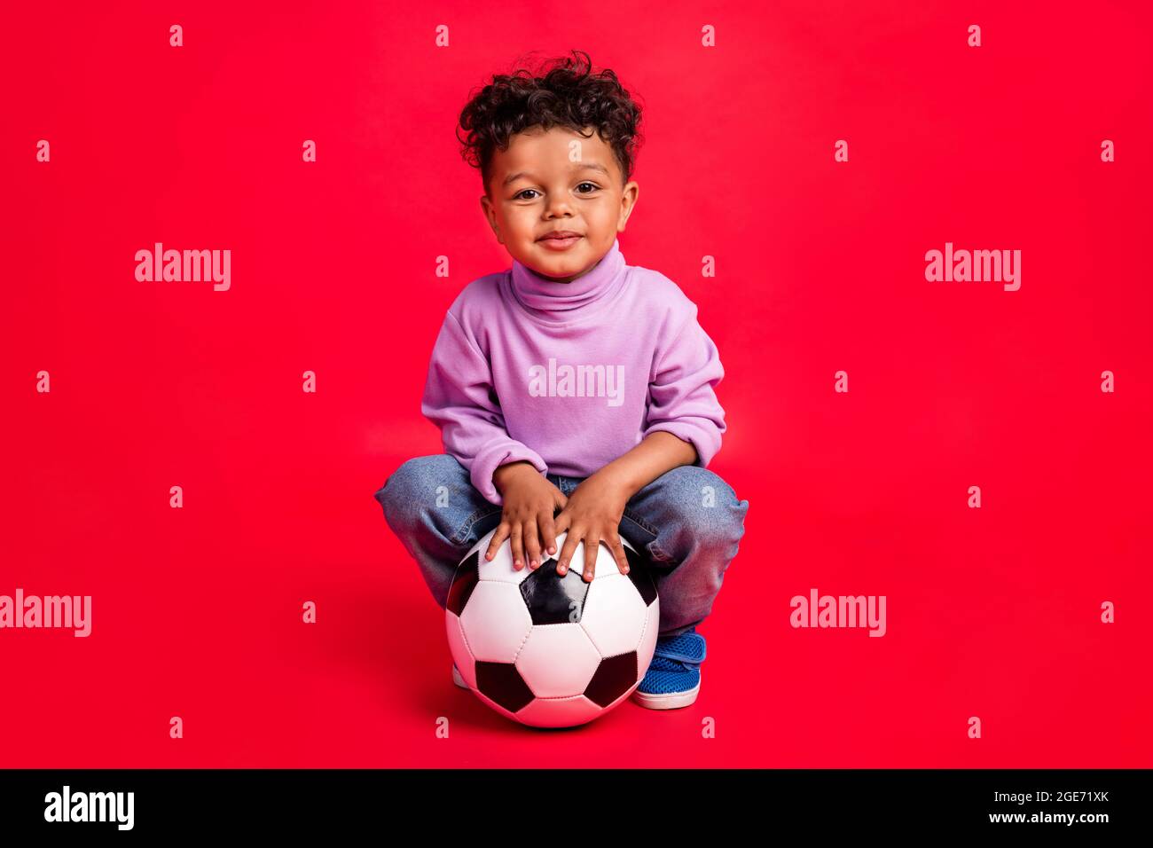 A little boy in panama, a yellow jersey, red shorts and white sneakers sits  on a yellow penny and holds a basketball multicolored ball, a soccer black  Stock Photo - Alamy