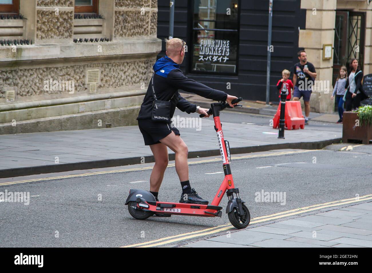 A man riding a VOI electric e scooter on a road in Bristol.Electric scooters  cannot be ridden on the pavements and the user must hold a drivers license  and comply by UK