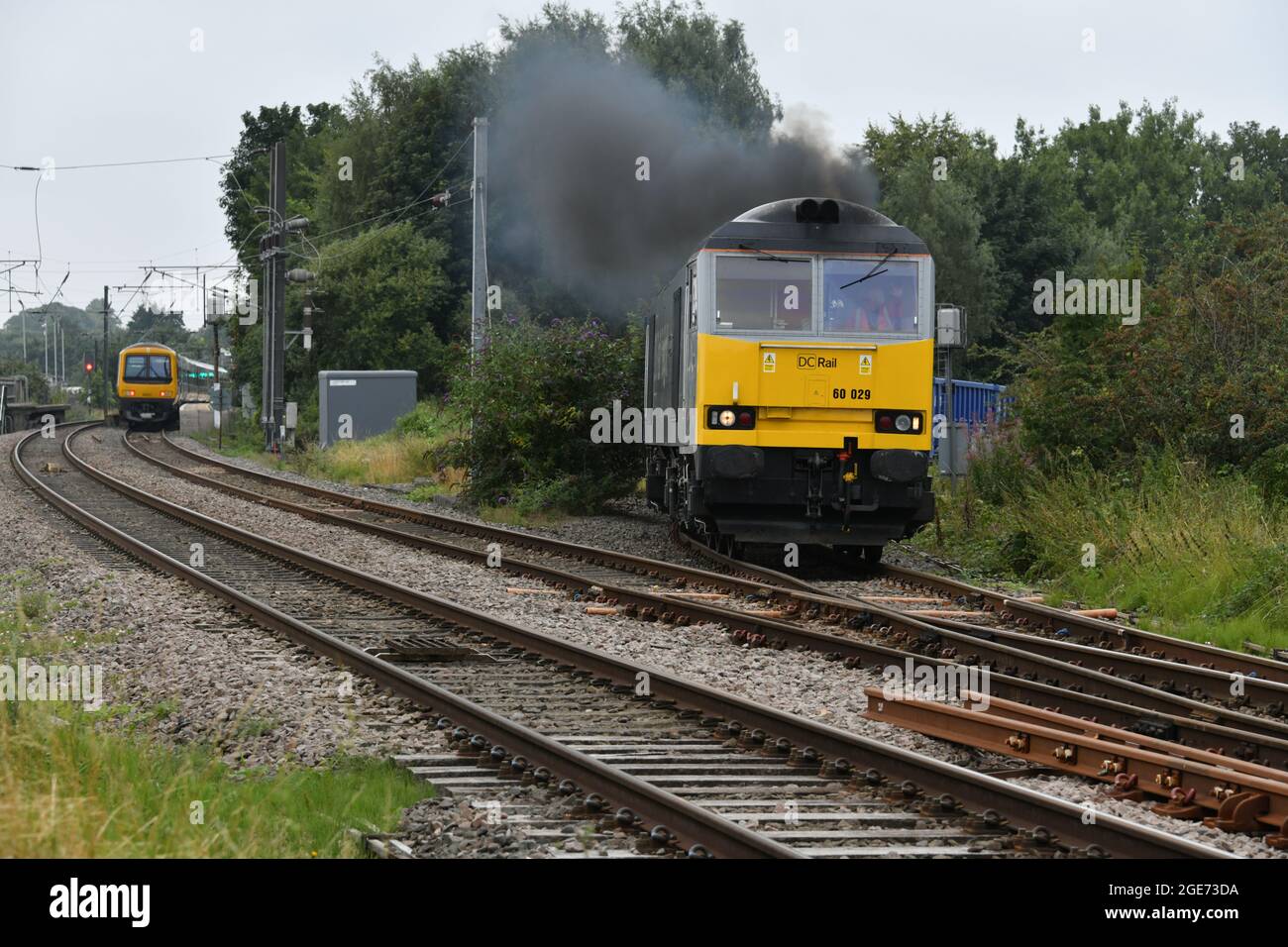 Clean & dirty forms of transport traction on show as Class 60 60029 Ben Nevis emits copious amount of exhaust fumes as it climbs up Lichfield chord Stock Photo