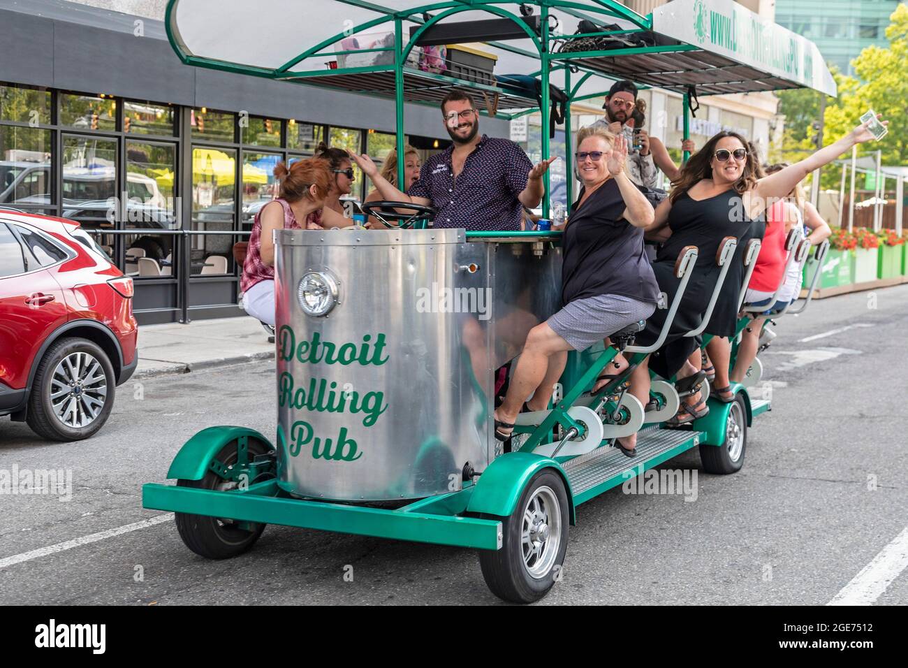 Detroit, Michigan - Happy partiers on a pedal pub in downtown Detroit. State and city laws allow groups to consume their own alcoholic drinks on pedal Stock Photo