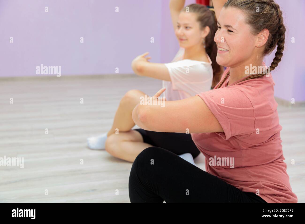 Girl dance instructor shows the elements of the number to another girl. Dance training. Stock Photo