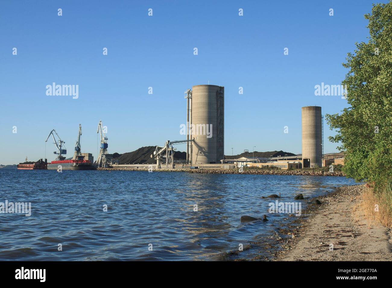 Barges at a power plant near Aarhus, Denmark, before changing from coal to biomass Stock Photo