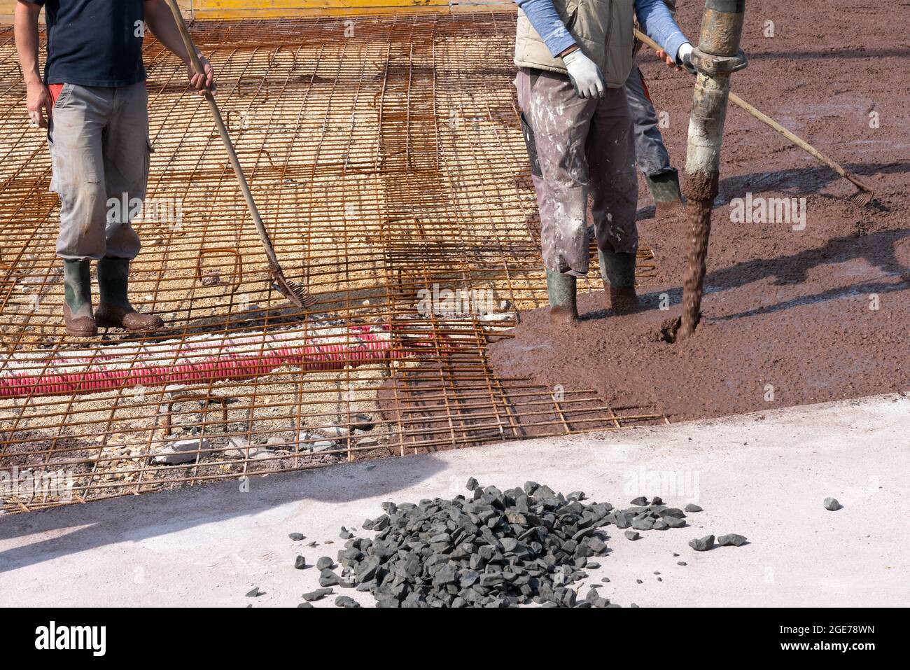 Builders works on the construction site: pouring brown concrete for foundation Stock Photo