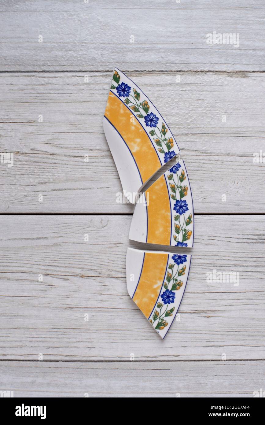 ceramic broken dish plate on wooden table.Flat lay Stock Photo