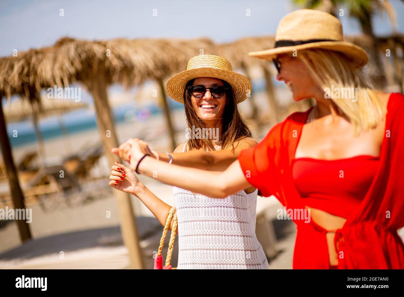Two pretty young women walking on a beach at summer Stock Photo - Alamy