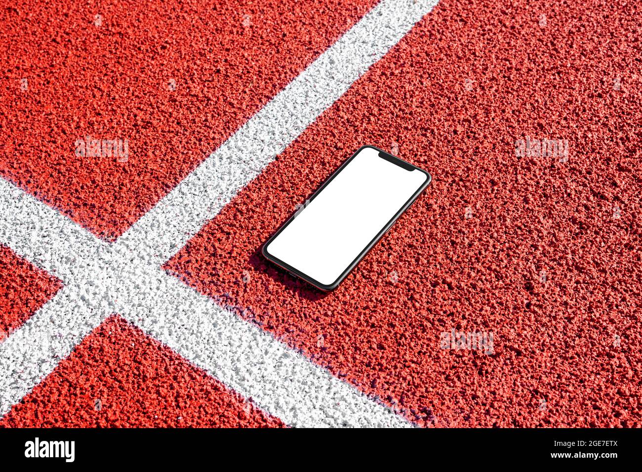 Phone mockup on running track. Isolated, white screen for app promotion Stock Photo