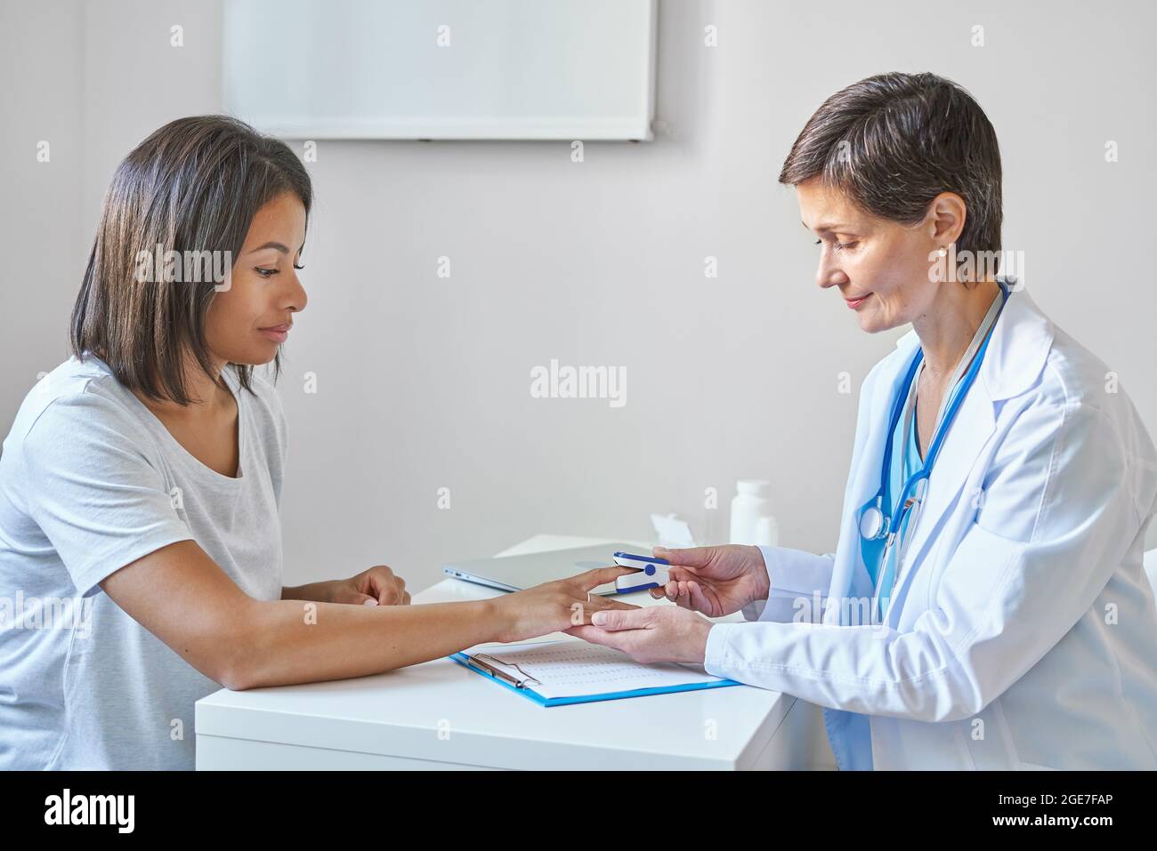 Mature female professional doctor measuring oxygen saturation of