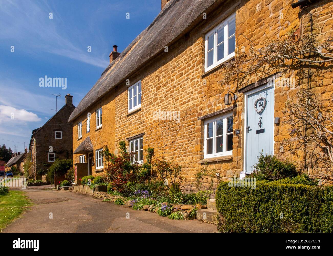 UK, England, Oxfordshire, Wroxton, Main Street, pretty thatched Cotswold stone cottages Stock Photo
