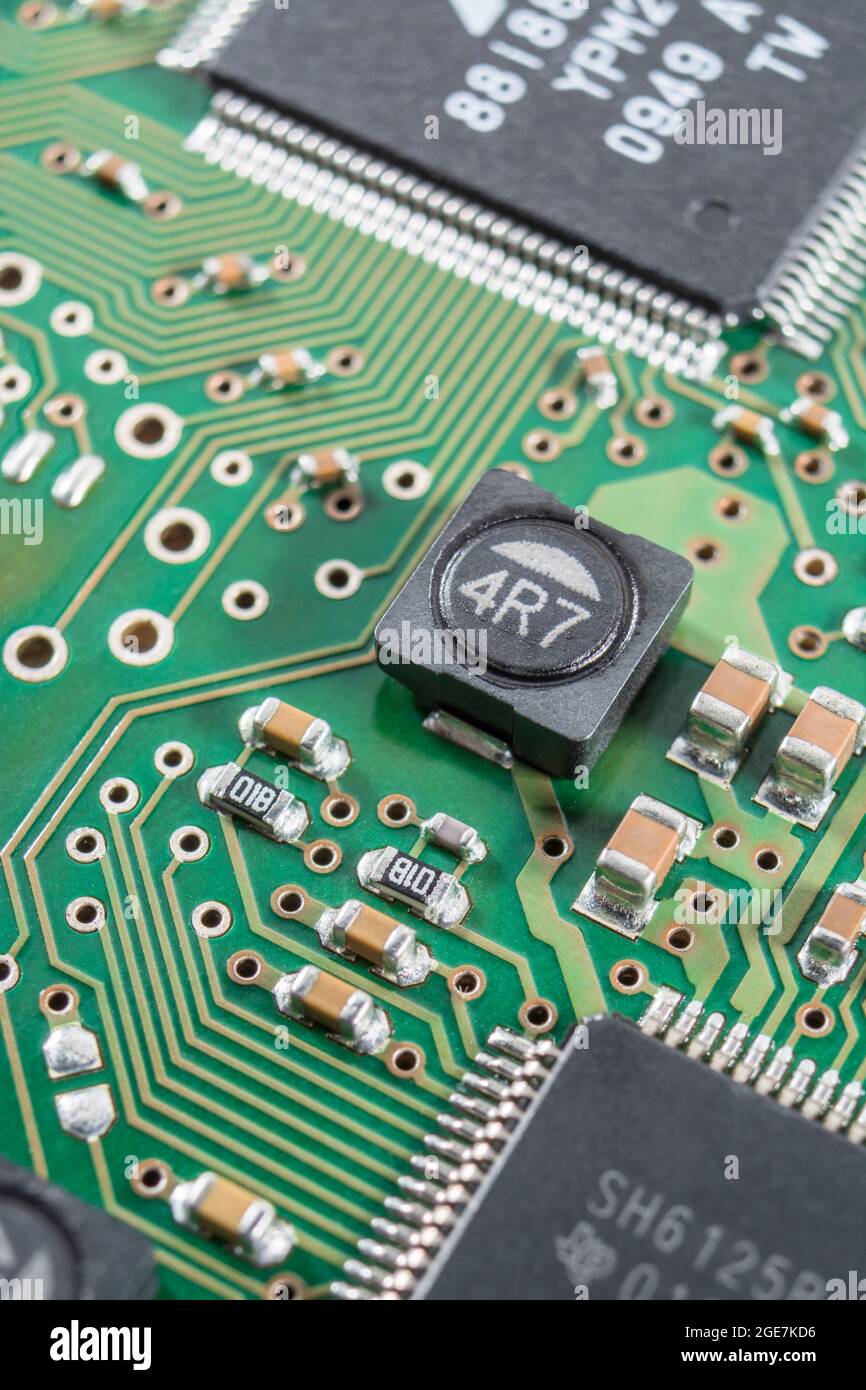 Close-up of a shielded power inductor on a surface mount / SM pcb (shielding cuts magnetic interference) + other SM components. Brands not known. Stock Photo